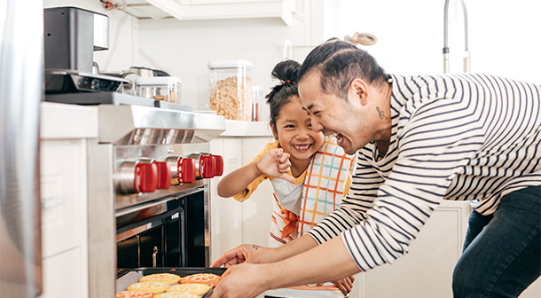 A father and daughter build their parent-child relationship by having some one-on-one time baking cookies together.