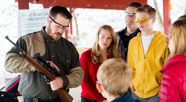 Adultos enseñando a los niños sobre la seguridad con las armas