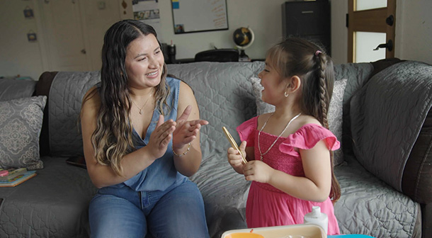 La mamá es quien le explica la actividad a la niña. 