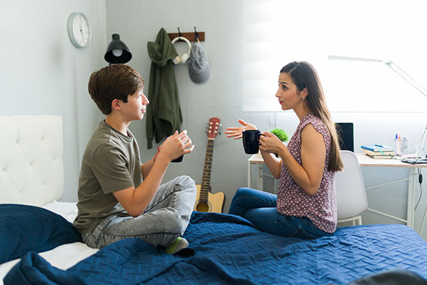 Teen and mom enjoying a coffee while talking to each other.
